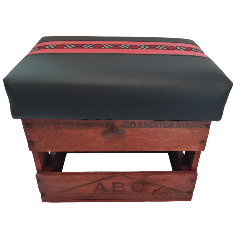 Wooden footstool with cushion and red and black accents on a white background.