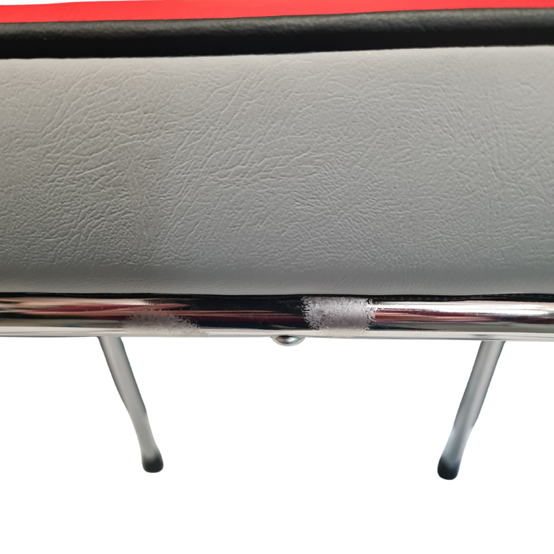 Close-up of a modern chair or bench with a light gray textured vinyl seat, a red top edge, a black trim line, and a polished chrome metal frame with legs, sh.wing touch up anti rust paint.