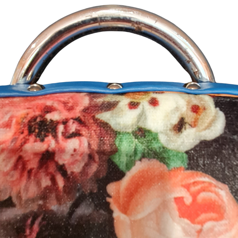 Close-up of a floral-patterned product with a metallic handle on a white background