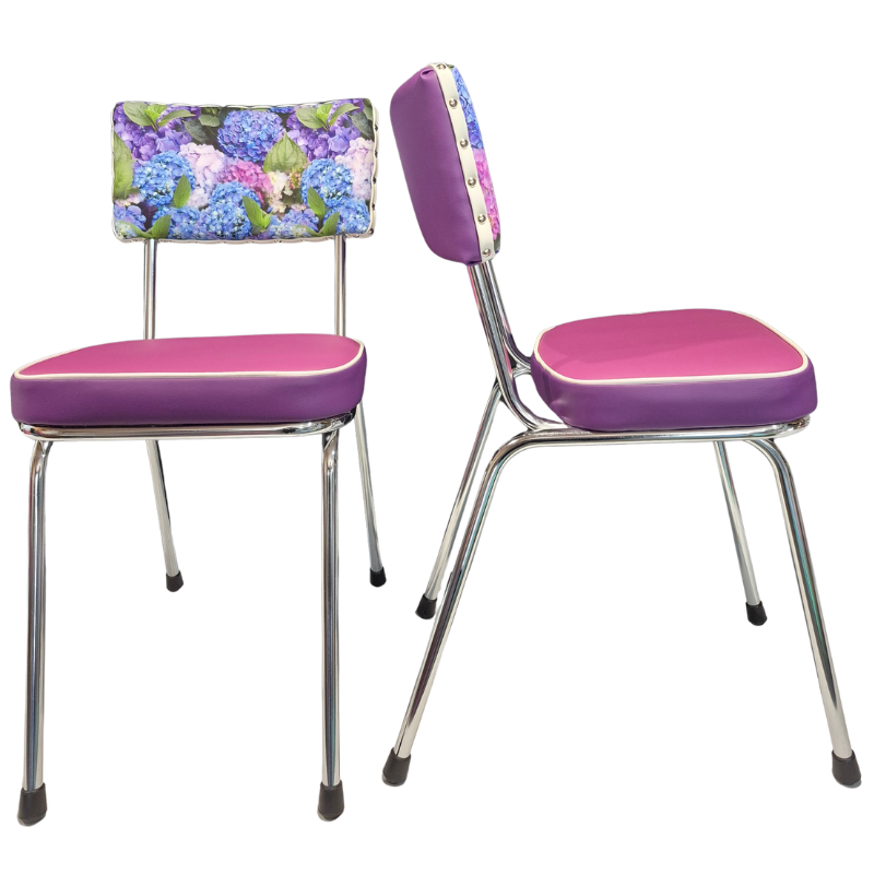 Two vintage-style dining chairs with purple vinyl seats and backs, chrome metal legs, and a hydrangea floral print backrest, shown on a white background.