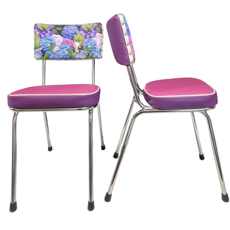 Two vintage-style metal dining chairs with purple upholstered seats and backs, one with a purple hydrangea floral backrest and one with a solid purple backrest, shown on a white background.